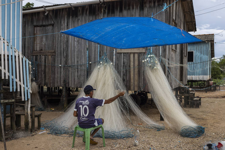 Nos últimos anos, a pesca artesanal viu a quantidade de peixes minguar devido à pesca em excesso de grandes embarcações; na foto, pescador faz reparo em sua rede na vila de Ajuruteua, no município de Bragança (PA)