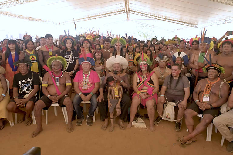 Sentado em meio a lideranças indígenas, cacique Raoni fala em microfone 