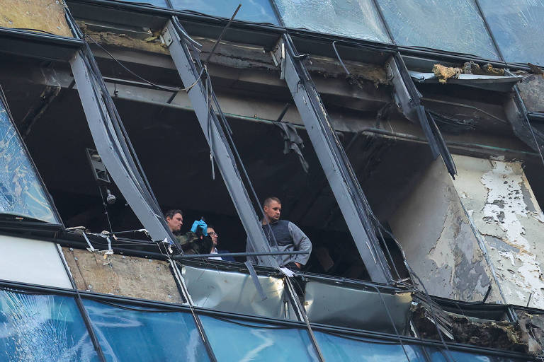 Investigadores analisam estragos no prédio IQ-Center, atingido por drone em Moscou