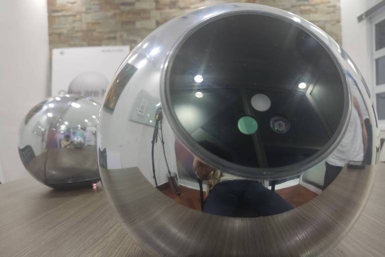 Dois orbs utilizados no cadastro de íris em ponto de coleta da Worldcoin no coworking Maac Hub, próximo ao Ibirapuera, na capital paulista. O dispositivo é uma esfera espelhada, que contém um círculo escuro com dois sensores e uma câmera