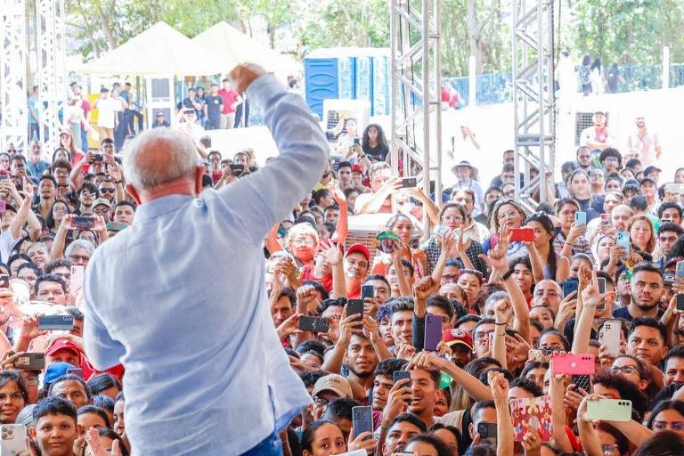 Lula é fotografado de costas, discursando para o público que levanta celulares para fotografá-lo