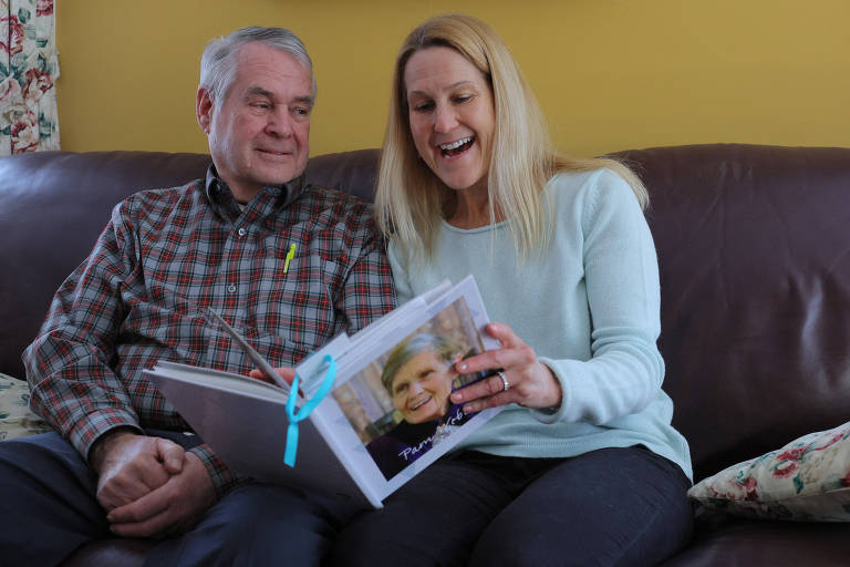 Wendy Nelson olha para um álbum de fotos de família com seu pai Richard, que tem a doença de Alzheimer