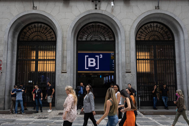 Mulheres caminham em frente à sede da B3, a bolsa de valores de São Paulo 
