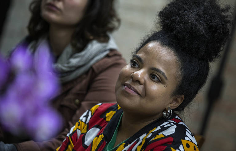 A vereadora Luana Alves, uma mulher negra com os cabelos presos e uma roupa colorida