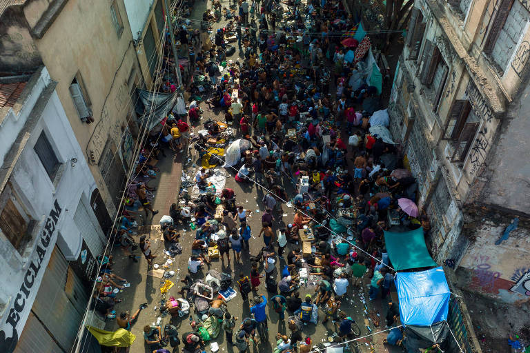 Fotografia colorida de vista aérea de rua no centro de São Paulo ocupada por usuários de drogas