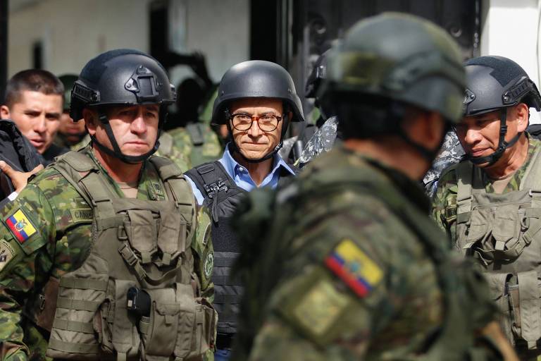 O jornalista Christian Zurita, ao centro, substituto do candidato à Presidência Fernando Villavicencio, que foi assassinado a tiros, deixa local de votação em Quito