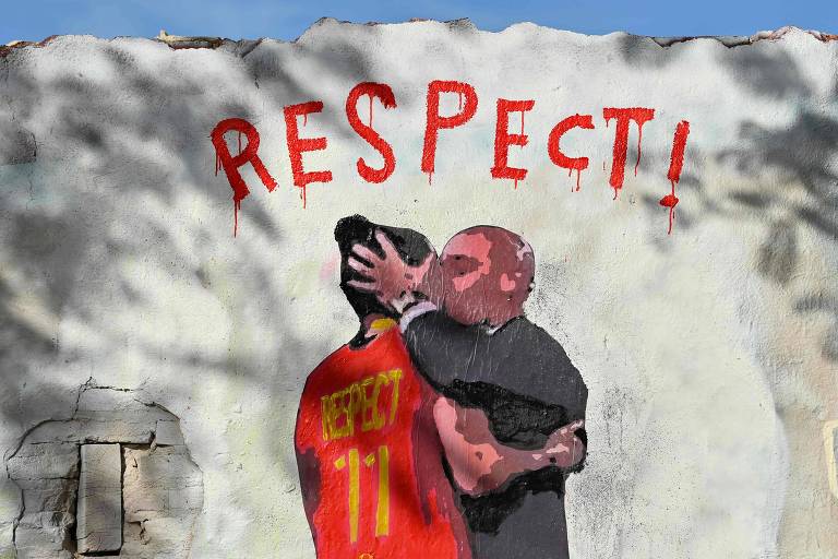 Mural do artista TV Boy em muro em Barcelona mostra desenho de cartola do futebol espanhol Luís Rubiales segurando a cabeça da jogadora Jenni Hermoso e beijando-a na boca.