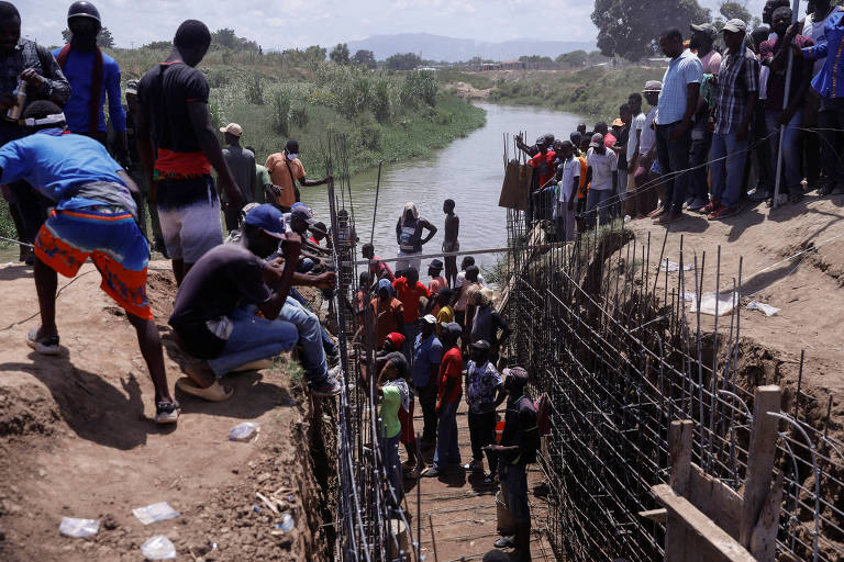 Haitianos reunidos em região onde é construído desvio para águas do rio Massacre, em Ouanaminthe