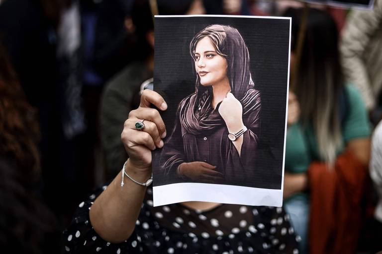Manifestante segura retrato de Mahsa Amini durante uma manifestação em frente à embaixada do Irã em Bruxelas, na Bélgica