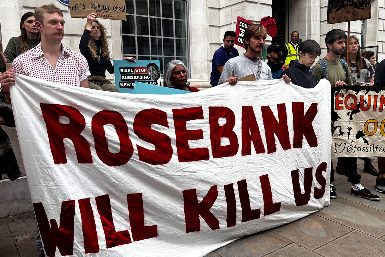 Pessoas seguram cartaz dizendo 'Rosebank will kill us' (Rosebank vai nos matar)