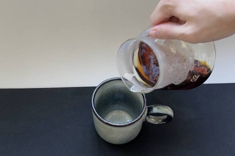 Café sendo servido de uma jarra de vidro em uma caneca