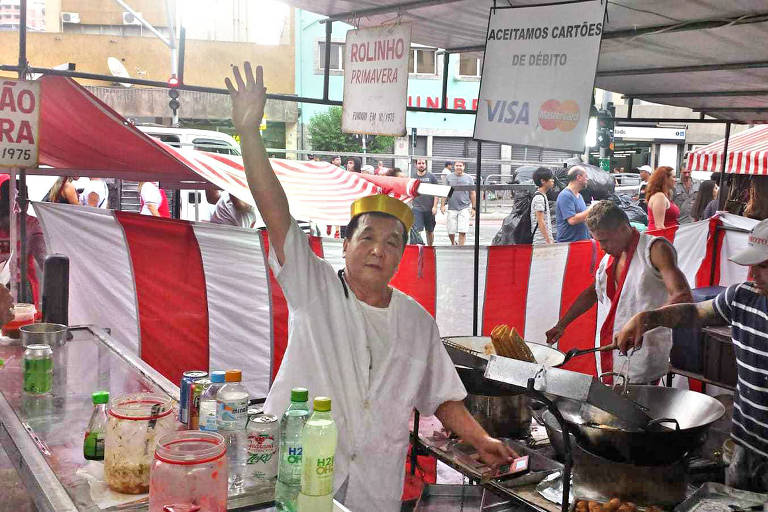 Comerciante David Chu na barraca do Masterchu em 2019, na feira da Liberdade, em São Paulo