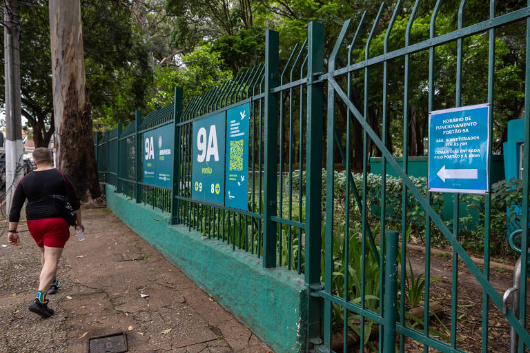 Homem caminha em calçada do lado de fora do Ibirapuera, na frente do portão 9A