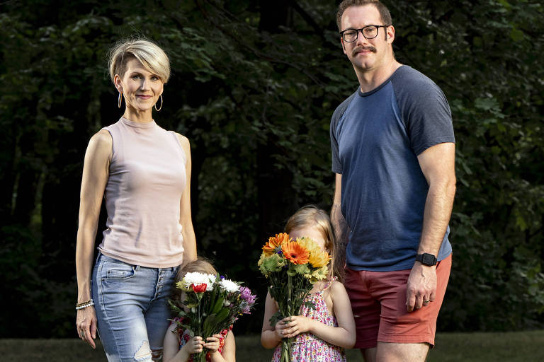 Lucy e Mike Fitzgerald posam com as filhas, que colocam ramos de flores em seus rostos para evitarem serem identificadas