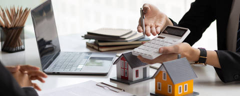 Empresário, agente imobiliário segurando uma calculadora, apresentando uma cotação de preço a um cliente para uma casa, hipoteca, arrendamento, aluguel, juros, taxa, empréstimo, juros. (Foto: Wasan/Adobe Stock )