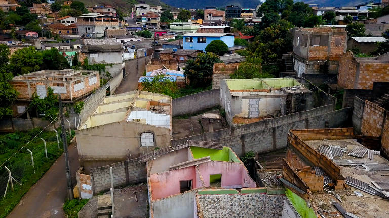 Foto aérea, colorida, feita com drone, mostra casas abandonadas e sem telhado.