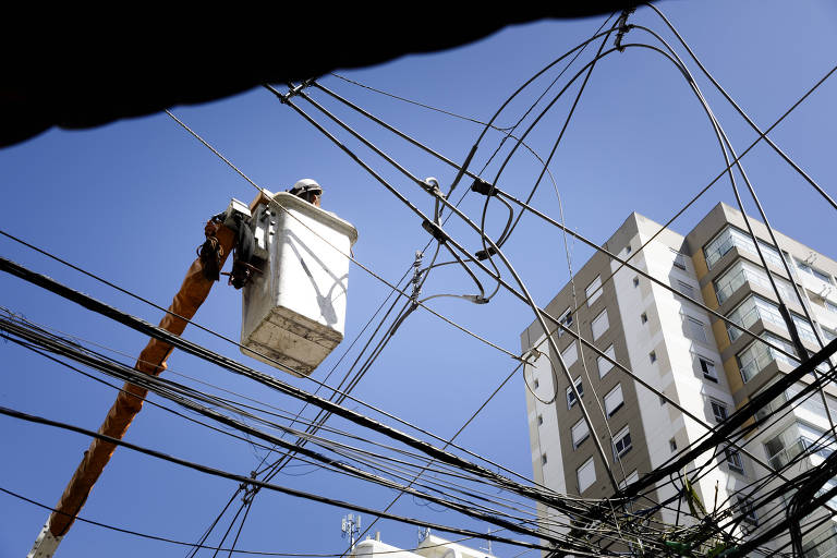 Funcionário da Enel faz reparos da fiação no bairro Moema, em São Paulo
