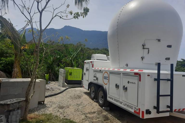 Caminhão que transporta radar meteorológico, equipamento oval branco, transita por estrada 