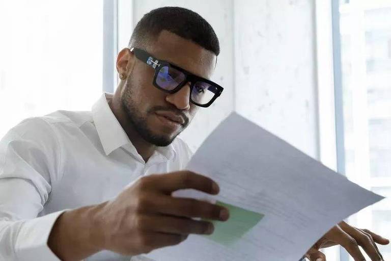 Homem lendo folha de papel
