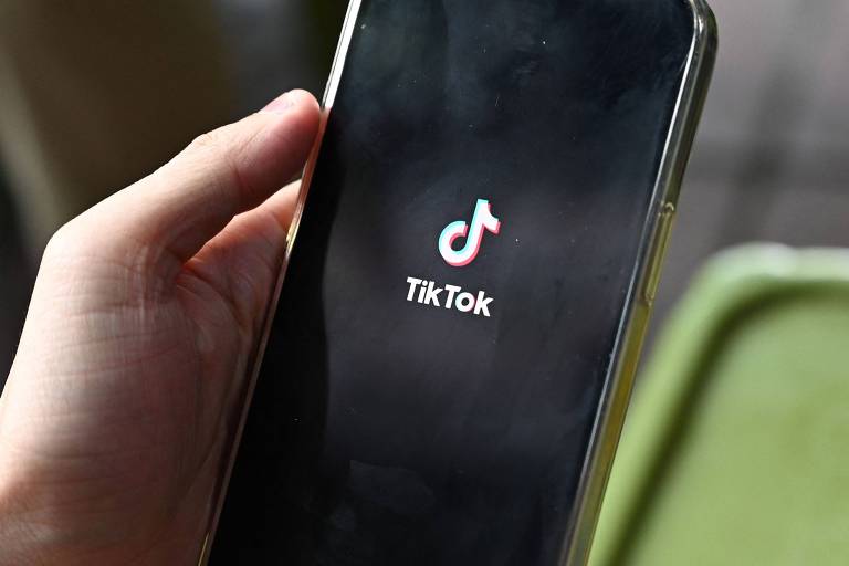 Homem segura celular com tela no aplicativo do TikTok