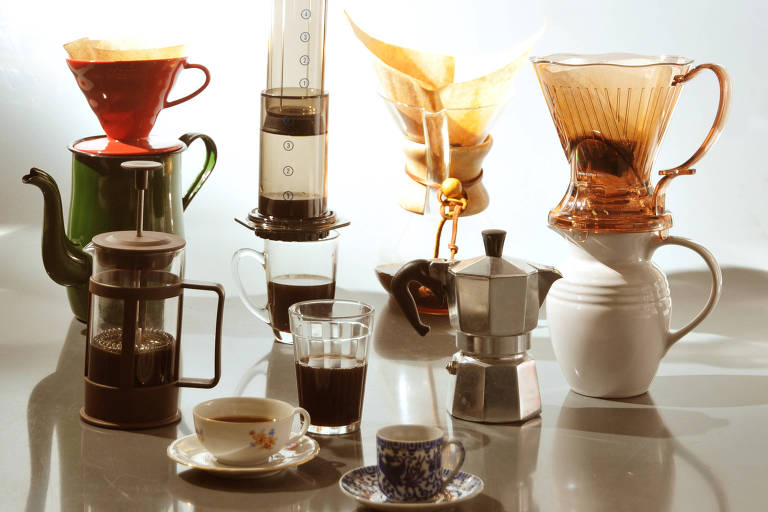 Vários utensílios para preparo de café sore uma mesa branca