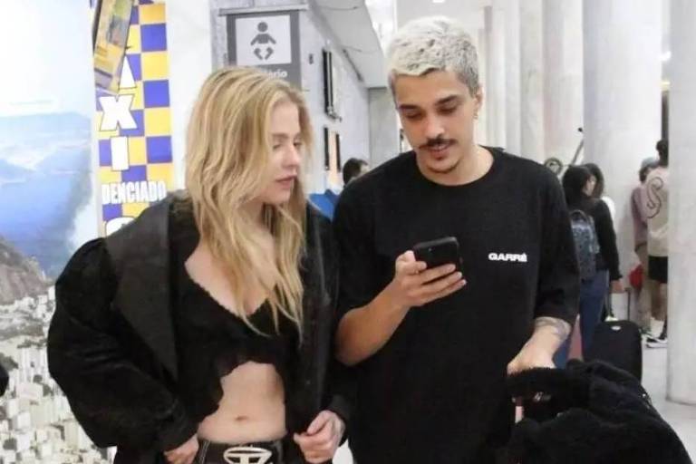 Em foto colorida, casal é flagrado no saguão de aeroporto