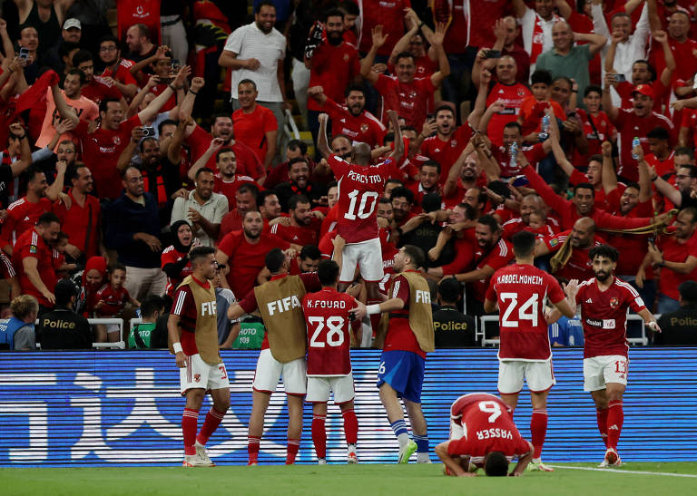 Jogadores do Al-Ahly comemoram o segundo gol marcado contra o saudita Al-Ittihad; eles levantam o camisa 10 em direção à torcida com vestes vermelhos