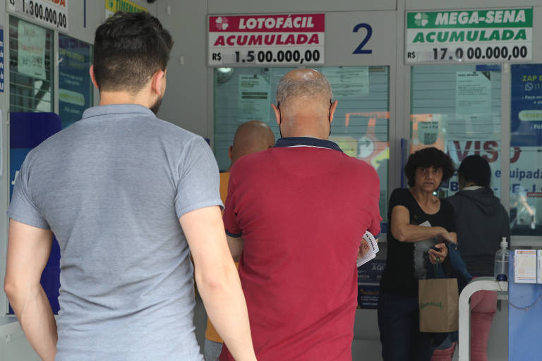 Pessoas estão na fila para pagamento em uma lotérica