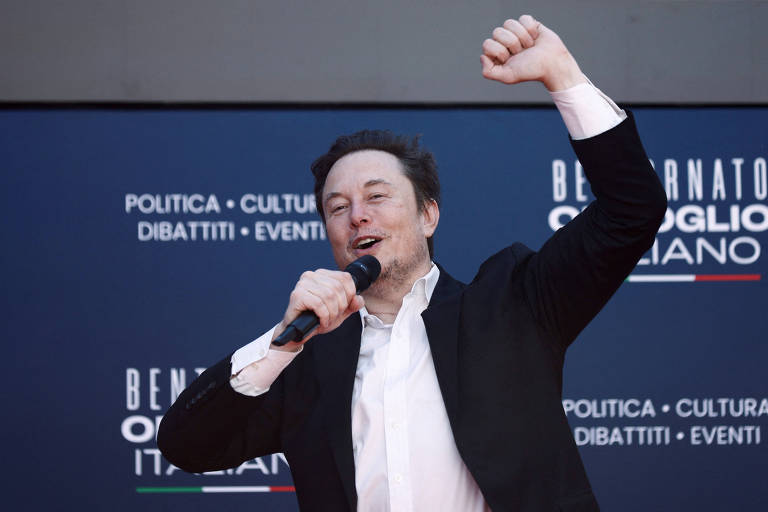 Elon Musk ergue o punho esquerdo em comemoração durante evento na Itália