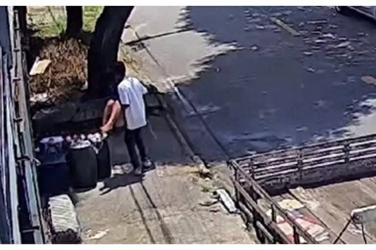 Imagem registrada por uma câmera de segurança mostra um homem de camiseta branca e calça jeans carregando uma menina de 12 anos no colo. Ele está prestes a colocá-la no chão