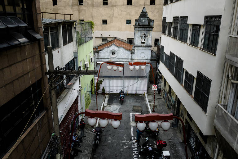 Imagem aérea mostra pequena igreja branca, com uma única torre, e quatro luminárias ornamentais