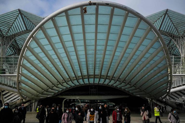 Pessoas aguardam para atravessar a rua, durante época de alta de casos de Covid, nos arredores da Estação do Oriente, na capital Lisboa