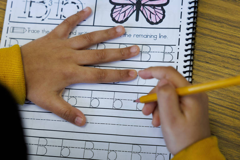 Aluno da escola elementar Luther Burbank pratica caligrafia em sala de aula