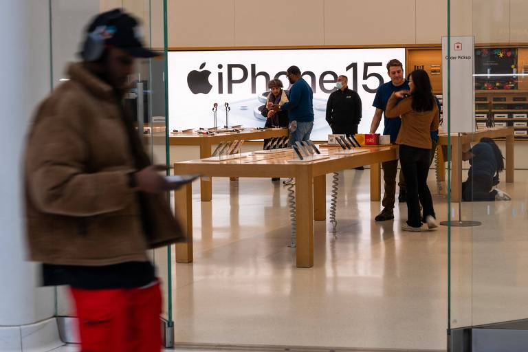 Pessoas caminham em frente à loja da Apple, em Manhattan, em Nova York, na qual é anunciado o iPhone 15