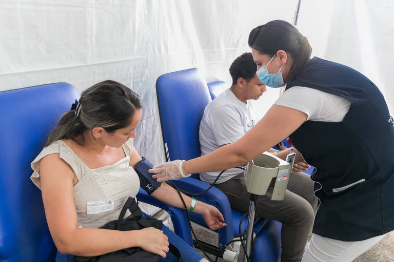 A auxiliar de enfermagem Gabriela Rodrigues, 32, faz teste para detecção de dengue na tenda da UPA 26 de Agosto, região de Itaquera, zona leste da capital paulista