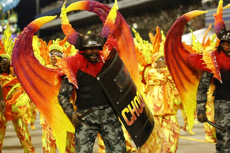 A ala 'Sobrevivendo no Inferno' no desfile da Vai-Vai homenageou o grupo Racionais MC's; na imagem, um policial do choque com chifres e asas de demônio