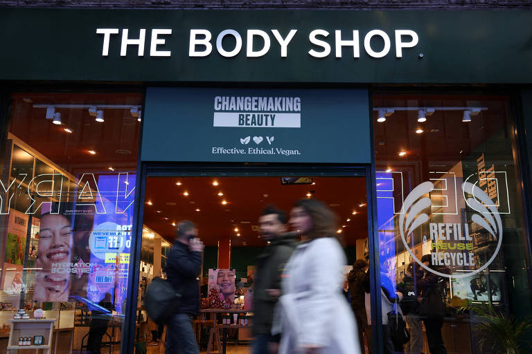 Consumidores caminham em frente à loja da The Body Shop em Londres
