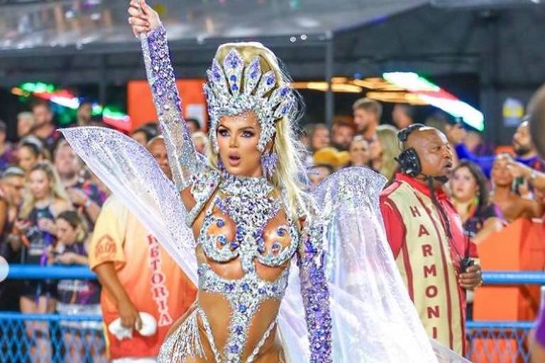 Em foto colorida, mulher é flagrada à frente da bateria de uma escola de samba