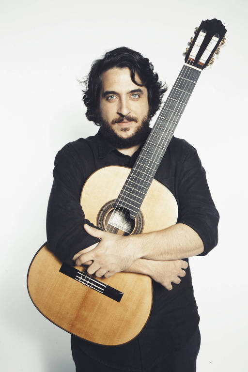 Em foto colorida o violonista João Camarero posa para a câmera
