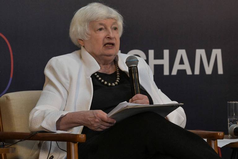 Janet Yellen fala ao microfone, sentada 