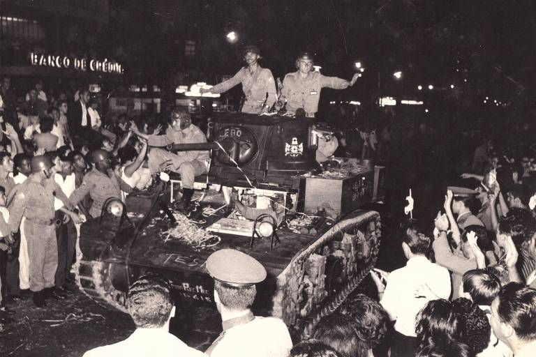 Festa nas ruas de Juiz de Fora (MG) para receber as tropas do general Olímpio Mourão Filho após o vitória do golpe militar de 1964;eles acenam para as pessoas em cima de um tanque de guerra