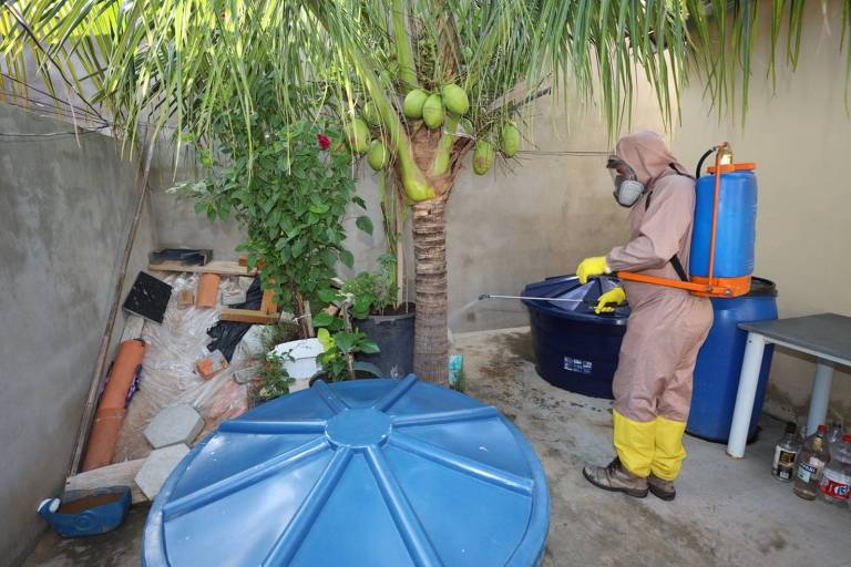 Homem com capuz e equipamento de fumacê