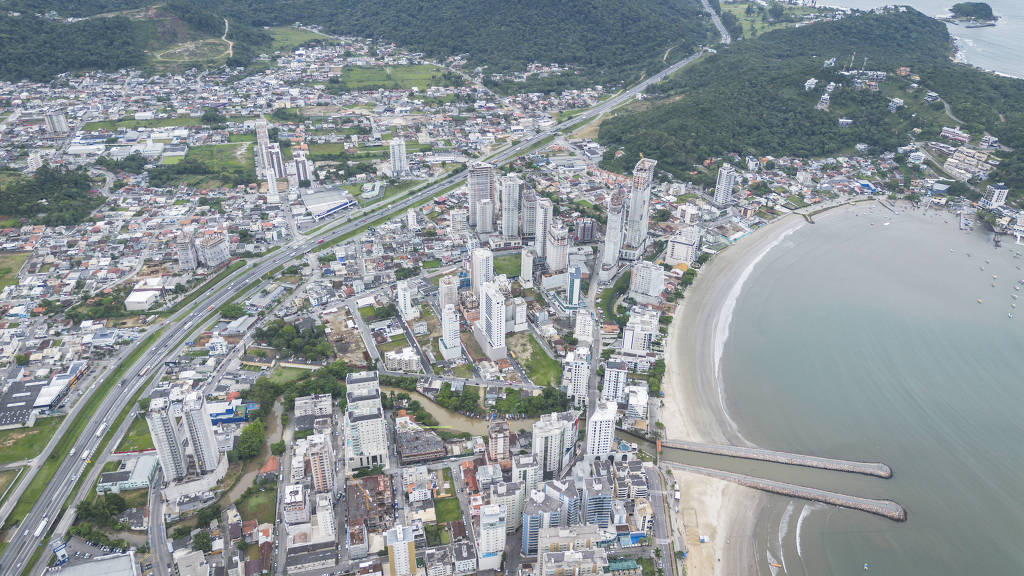 vista aérea de mar à direita, de prédios no meio e de BR-101 à esquerda