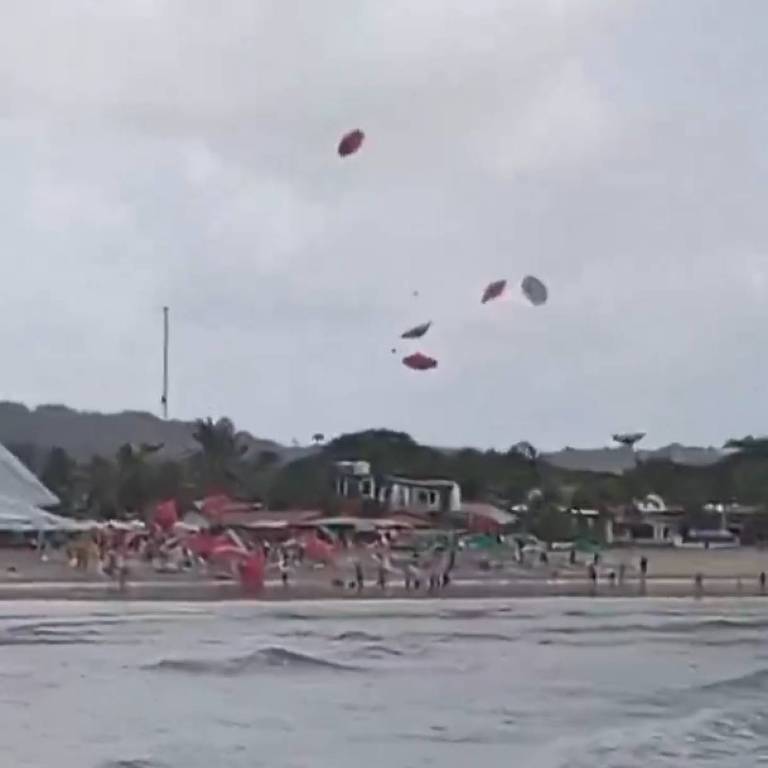 Guarda-sóis voam sobre a praia de Genipabu