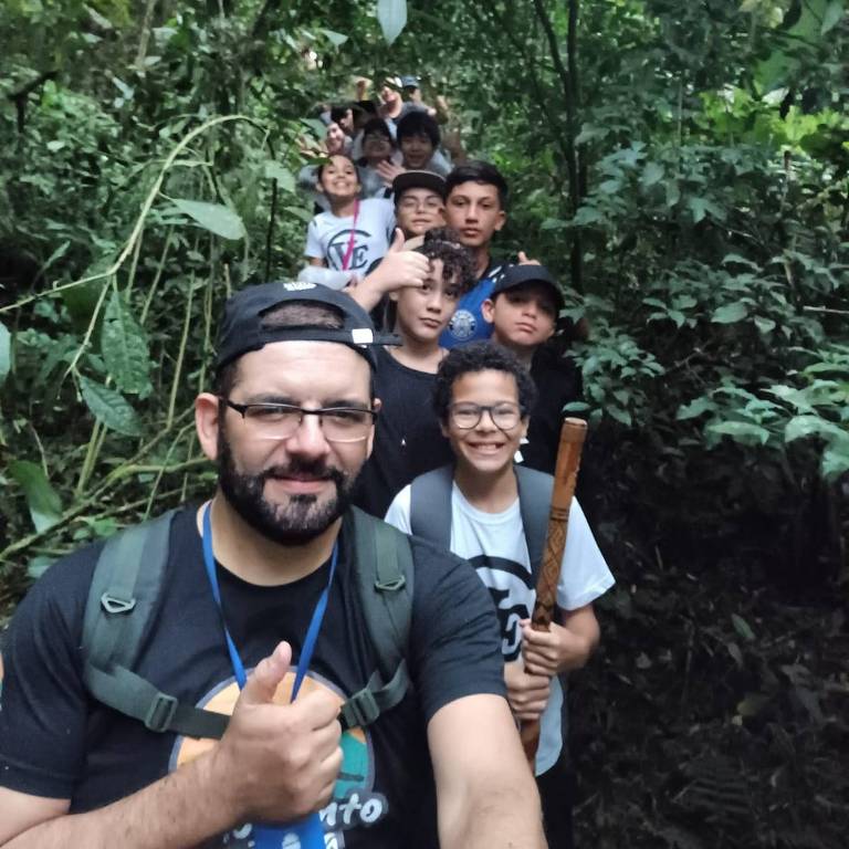 O professor Cristiano Ricardo Cardoso, com alunos em área de mata atlântica