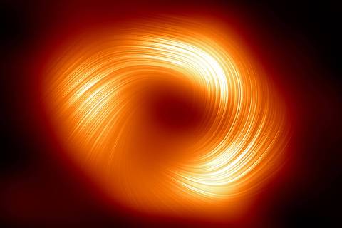 This handout image released by The European Southern Observatory on March 27, 2024, shows the polarised view of the Milky Way black hole, with lines marking the orientation of polarisation related to the magnetic field around the shadow of the black hole. Astronomers have discovered powerful magnetic fields that spiral around the supermassive black hole Sagittarius A*, located at the heart of the galaxy, the European Southern Observatory (ESO) announced on March 27, 2024. (Photo by Handout / European Southern Observatory / AFP) / RESTRICTED TO EDITORIAL USE - MANDATORY CREDIT 