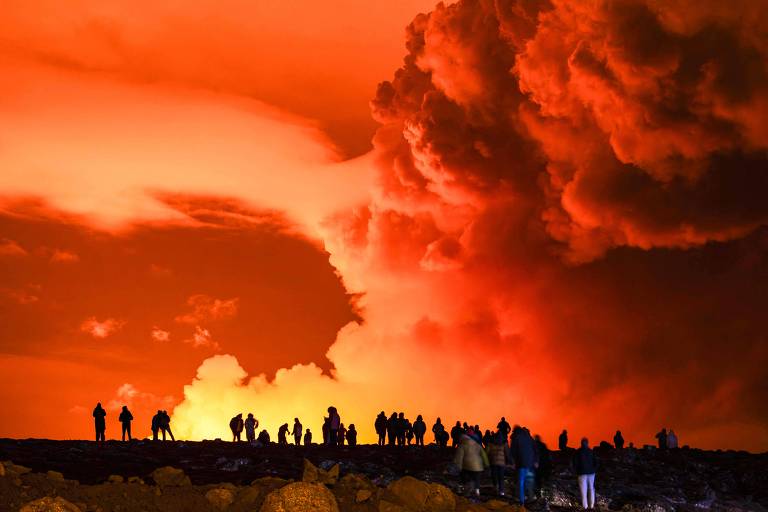 Pessoas observam erupção de fissura vulcânica na península de Reykjanes, na Islândia