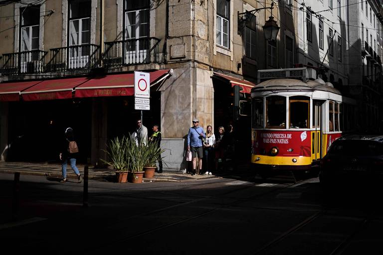 Pessoas aguardam o bondinho em Lisboa, capital de Portugal, onde uma pesquisa revelou que a maior parte das famílias teve dificuldades para pagar as contas em 2023