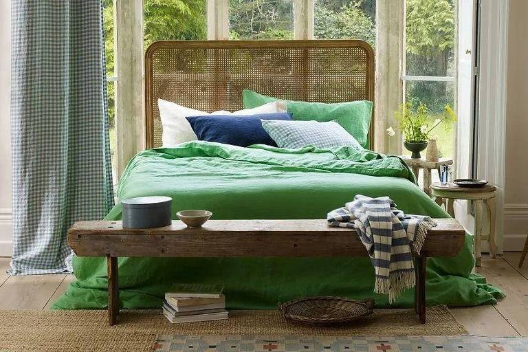 Cama com lençóis nas cores verde, azul e branco