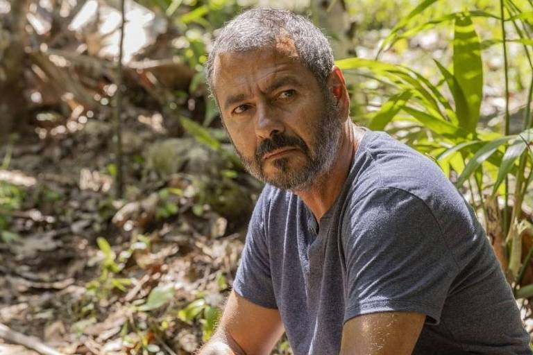 Em foto colorida, homem aparece no meio de uma plantação de cacau em cena de uma novela